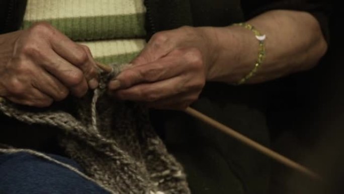 编织毛衣的女人的手。特写。