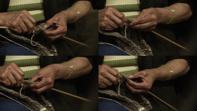 编织毛衣的女人的手。特写。