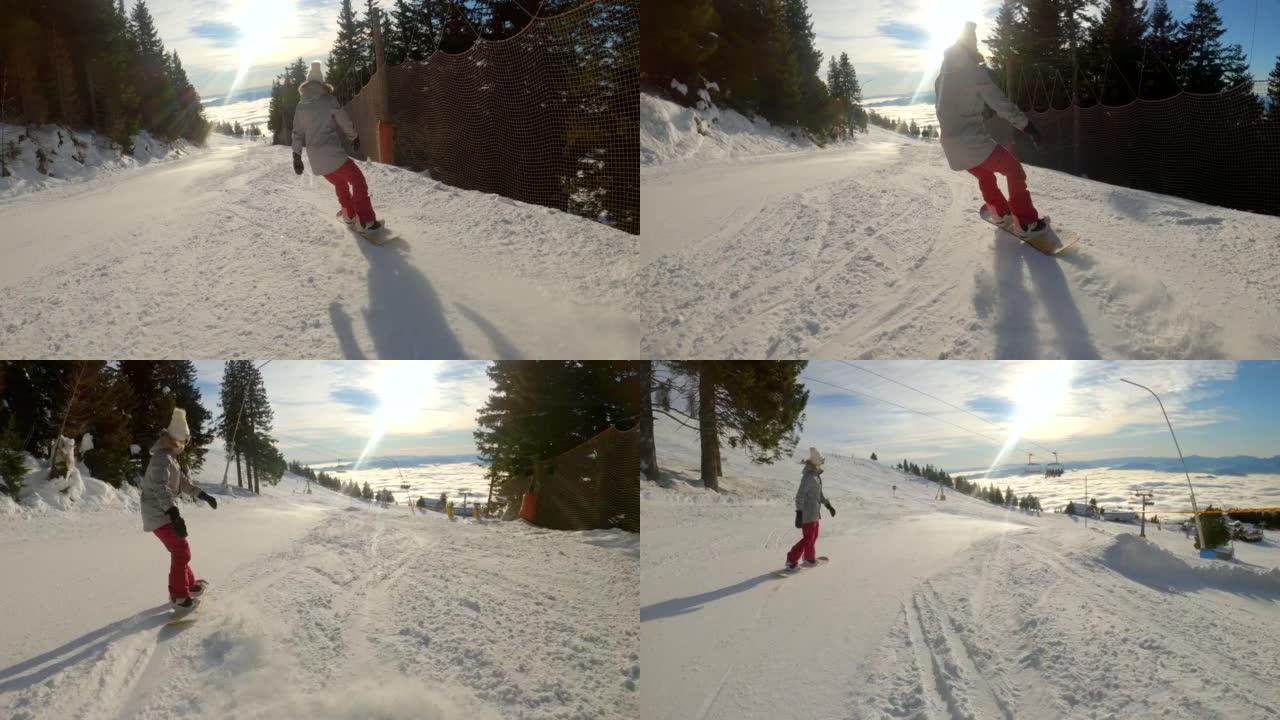 在山区阳光明媚的冬日，滑雪板的女人沿着山坡骑行