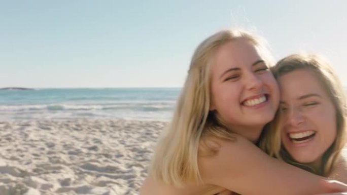 快乐的女人在海滩上拥抱女朋友，在脸颊上亲吻惊喜最好的朋友玩得开心暑假