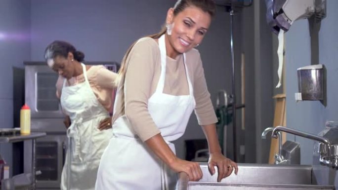 妇女在面包店厨房工作，打扫卫生