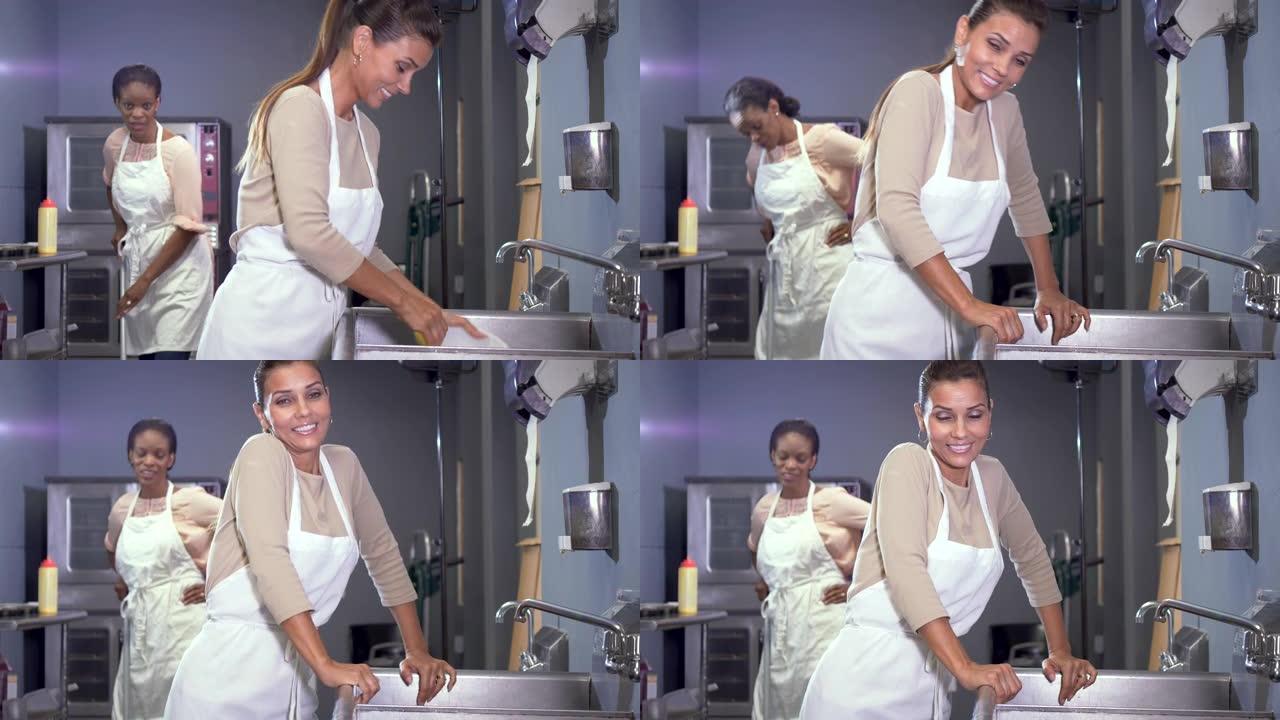 妇女在面包店厨房工作，打扫卫生