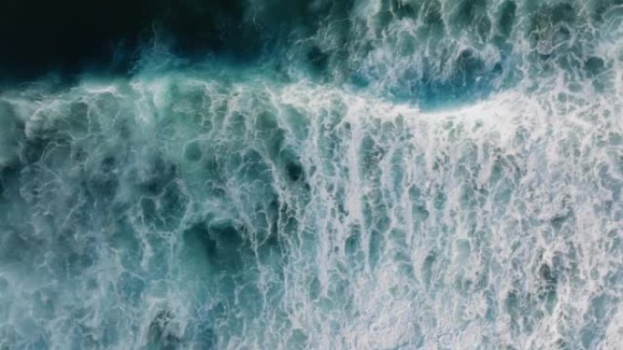 自上而下的鸟瞰图美丽的巨大蓝色海浪撞击和泡沫与白色洗涤背景