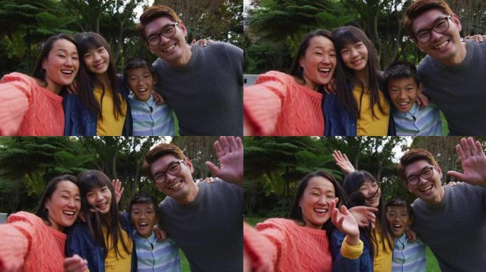 快乐的亚洲母亲与快乐的丈夫，儿子和女儿在花园里自拍