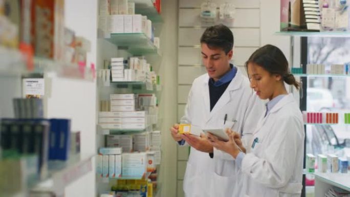年轻的药剂师顾问正在药店的货架上检查片剂药品。