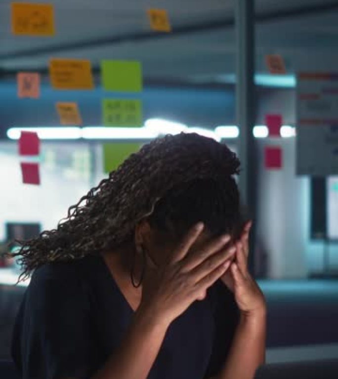 垂直屏幕: 深夜在办公室工作的非裔美国女商人在笔记本电脑上工作。疲惫的女性企业家试图找到解决商业问题