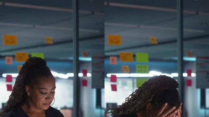 垂直屏幕: 深夜在办公室工作的非裔美国女商人在笔记本电脑上工作。疲惫的女性企业家试图找到解决商业问题