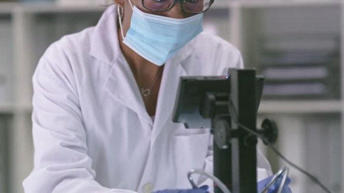 在实验室中使用数字显微镜的成熟科学家的4k视频片段