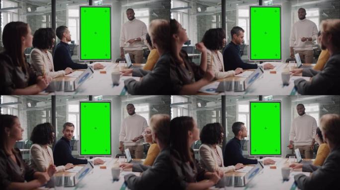 项目经理在机构会议室的一个年轻的多元化创意团队的绿屏模拟显示器上进行演示。同事们坐在会议桌后面讨论业