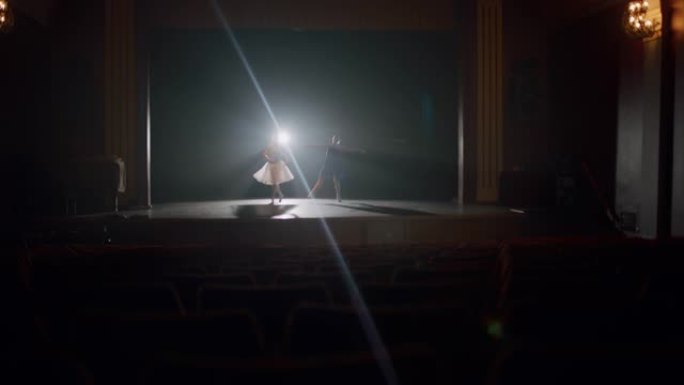 SLO MO两名年轻的芭蕾舞演员在空荡荡的剧院舞台上排练
