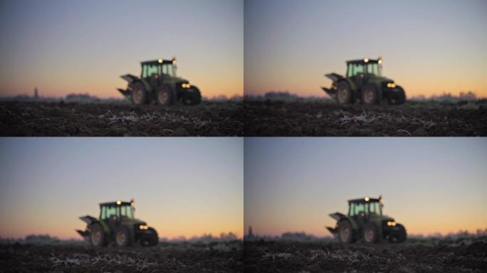 日出时农田土壤后面的拖拉机