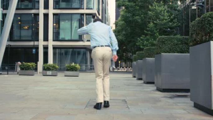 一个年轻商人在城市跳舞的4k视频片段