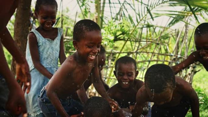 一群非洲孩子，在农村嬉笑嬉水。黑人孩子快乐地庆祝生活。镜头捕捉了童年的美丽，村庄生活的天真和纯洁