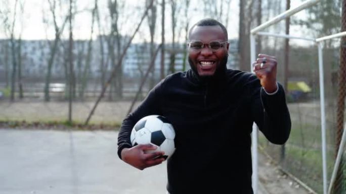 非洲男球员手持足球球举起拳头的肖像