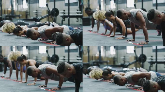 一群运动的年轻人在健身房一起俯卧撑的4k视频片段