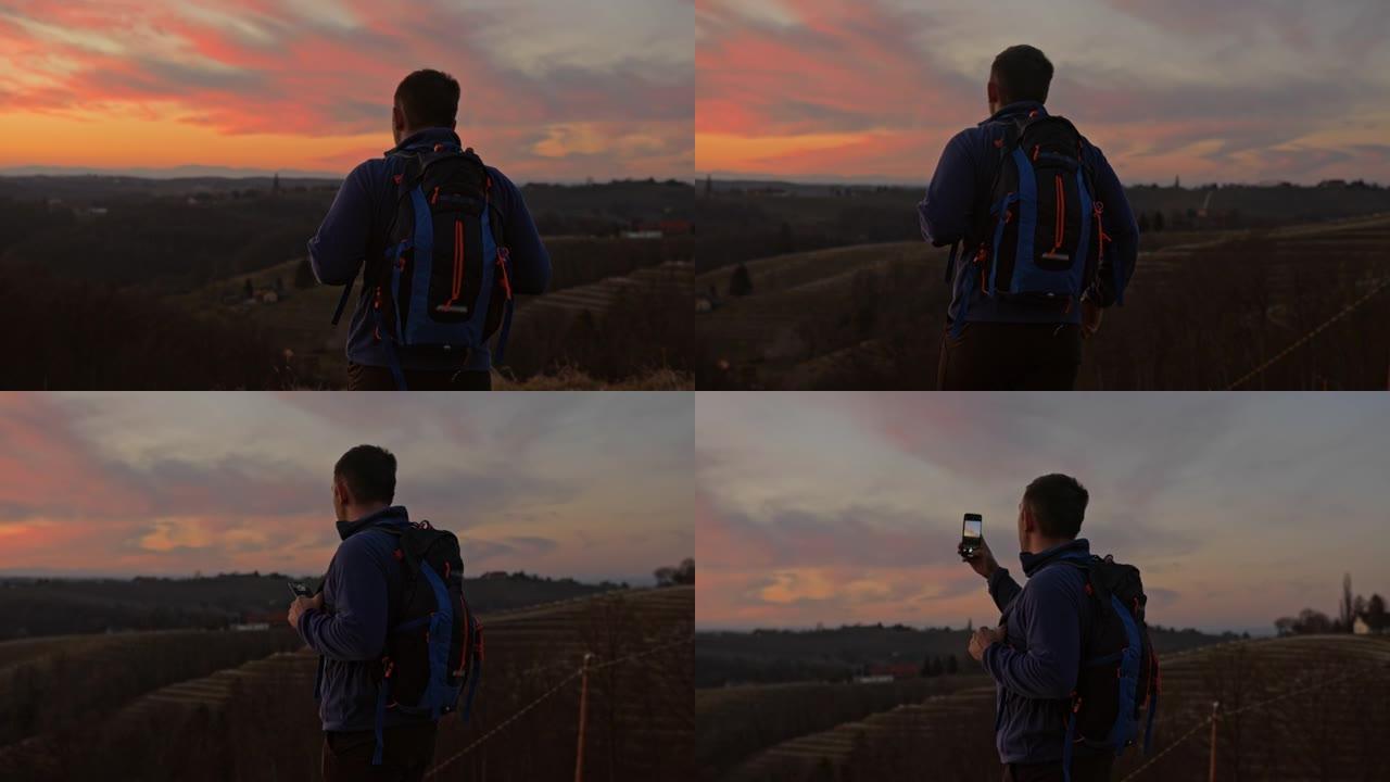 男子在山区景观上使用手机拍照