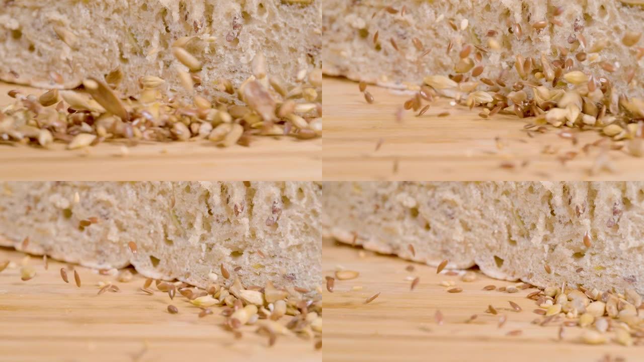 宏观: 闪亮的红色和棕色亚麻籽落在一块切成两半的质朴面包上