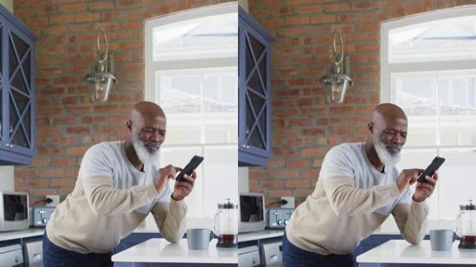 一名资深非裔美国人使用智能手机俯身在厨房小岛上的垂直镜头