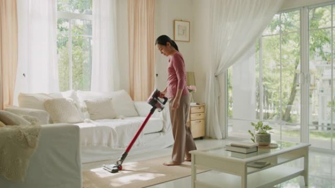 家庭主妇用吸尘器打扫房子