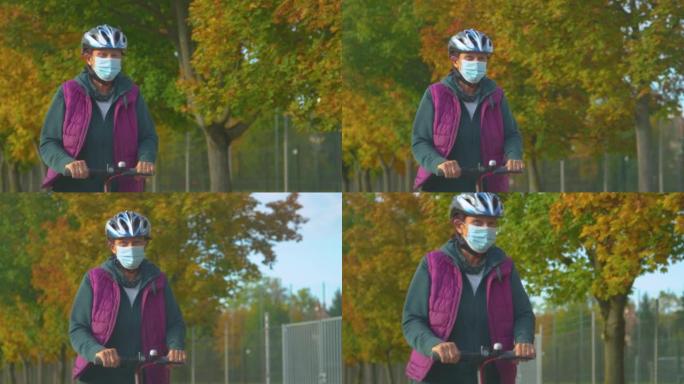 特写: 戴着口罩的快乐老妇带着电动踏板车四处行驶