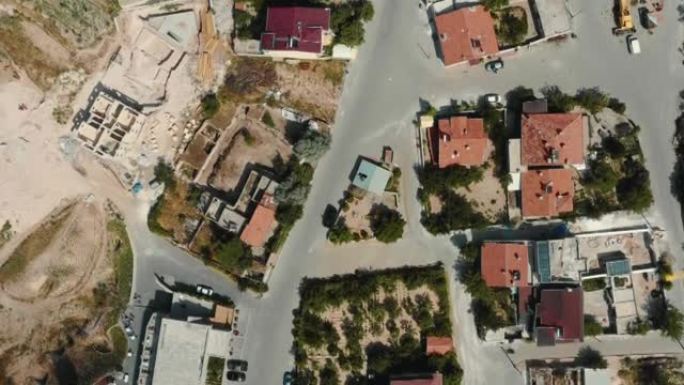 在夏季土耳其，俯视图无人机飞越美丽的阳光明媚的小镇，小镇上有房屋和方形城市街道。