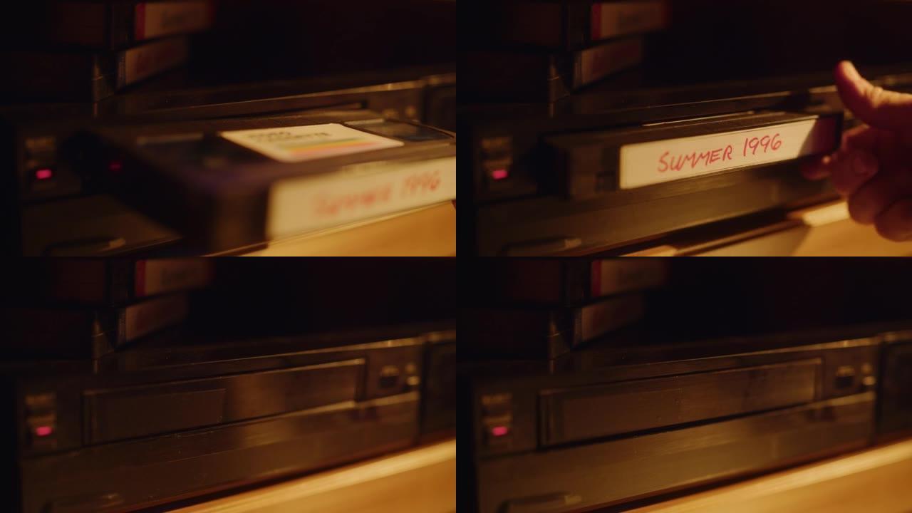 一个人在播放器中插入VHS盒式磁带的特写镜头，并带有家用摄像机的怀旧夏日镜头。复古90年代技术概念。