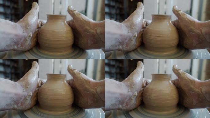 工匠肮脏的手在陶工的轮子上旋转的陶瓷锅的电影院环
