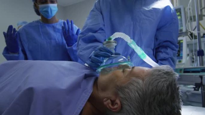 混血外科医生穿着防护服使患者在手术室中入睡