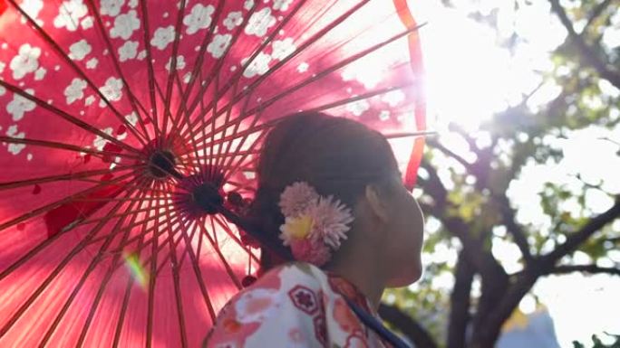 穿着和服的女人在晴天打开雨伞