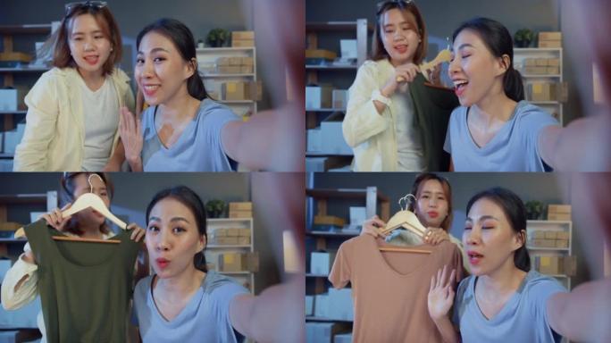 两名年轻的亚洲女孩时装设计师自拍看相机在线直播展示新系列产品晚上在商店收到顾客的订单。小企业，在线市