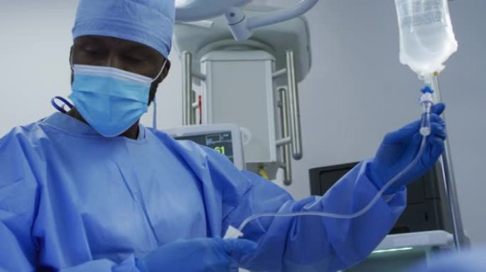 非裔美国男性外科医生穿着防护服在手术室里滴水
