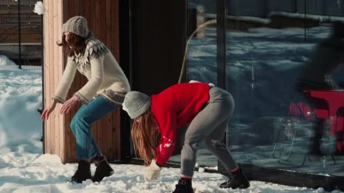 快乐的多民族朋友在阳光明媚的冬季圣诞派对慢动作中互相扔雪球。