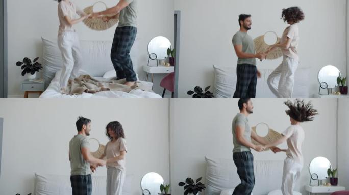 欢快的混血夫妇在床上跳舞的倾斜肖像在家里玩得开心