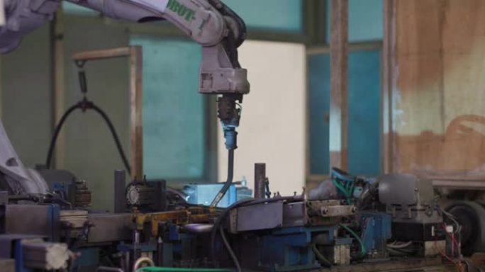 现代焊接自动化机器在生产工厂车间焊接带有明亮火花的金属。智能工业机器人手臂数字化工厂技术现代化。物联