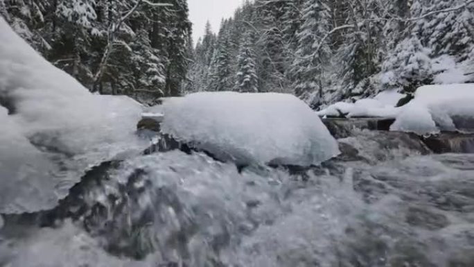 冬季森林中的山河。冰冷的岩石和白雪皑皑的树木。冰雪融化成强大的水流。全球变暖概念