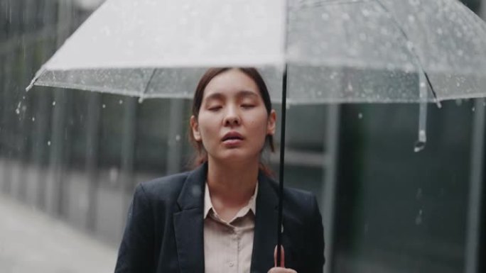 寂寞悲伤的女人在大雨中撑着伞站着