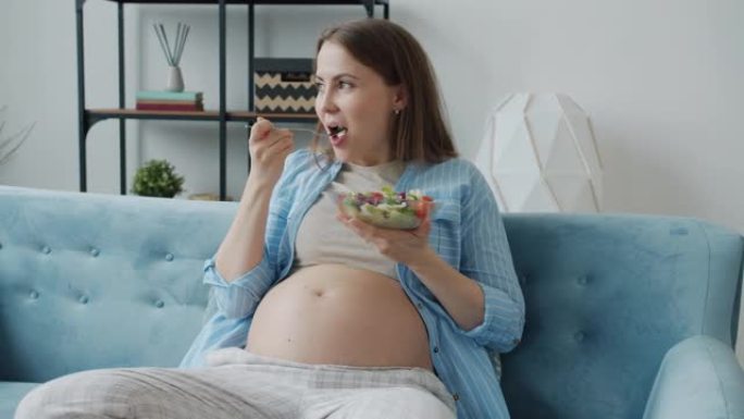 美丽的孕妇吃蔬菜沙拉在家享受健康餐