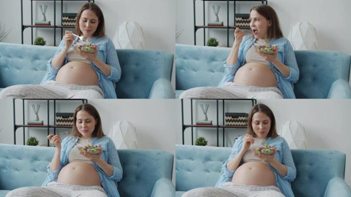 美丽的孕妇吃蔬菜沙拉在家享受健康餐