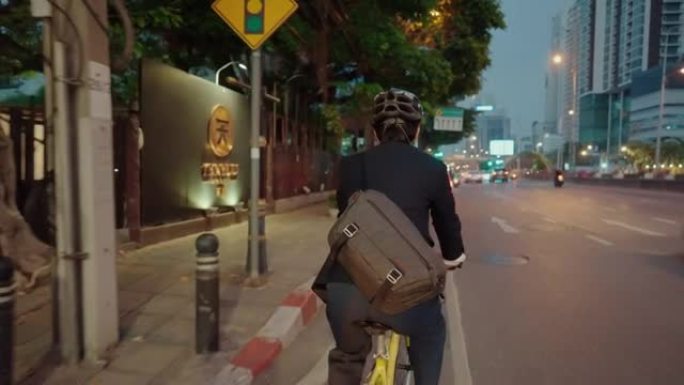 商人下班后骑着自行车穿过城市。