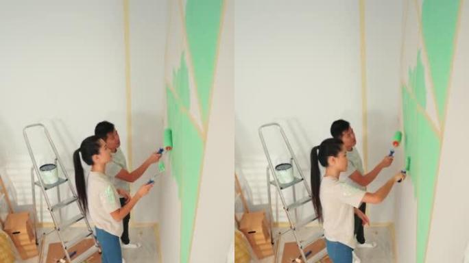 年轻夫妇在家里的墙壁上涂上绿色的海蓝宝石。