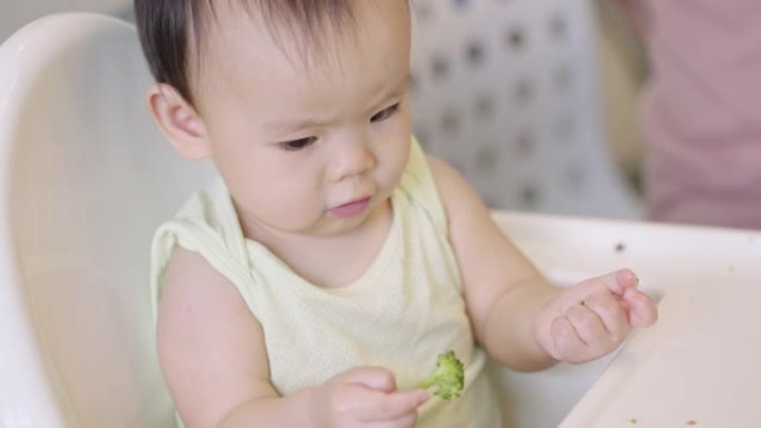 亚洲可爱小女孩用手吃西兰花