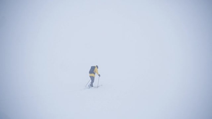 在极端天气的冬季，活跃的运动员滑雪板在splitboard上巡回演出