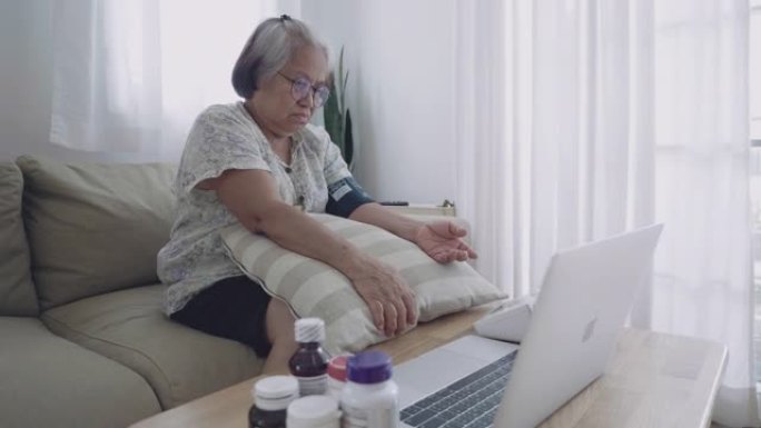 用笔记本电脑测量血压的高级女性