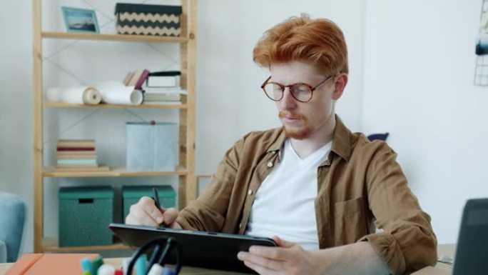 在公寓室内工作的平板电脑屏幕上的年轻男性专家素描的慢动作