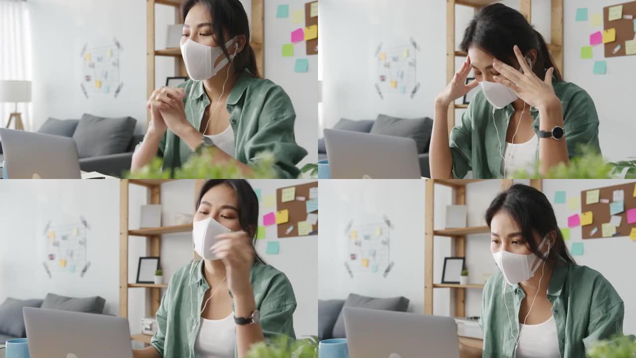 亚洲女商人在客厅在家工作时，使用笔记本电脑戴着医用口罩与同事谈论视频通话计划。
