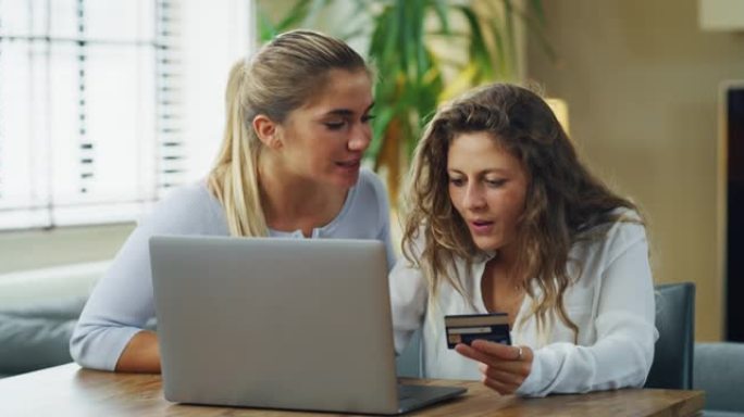 年轻女性女友的真实照片正在使用智能手机输入信用卡信息，同时在家里的客厅一起在线购物。