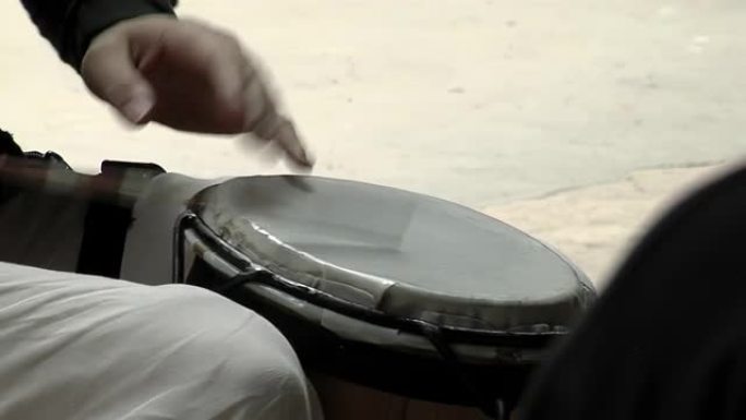 拉丁打击乐手用手和鼓槌打鼓。特写。