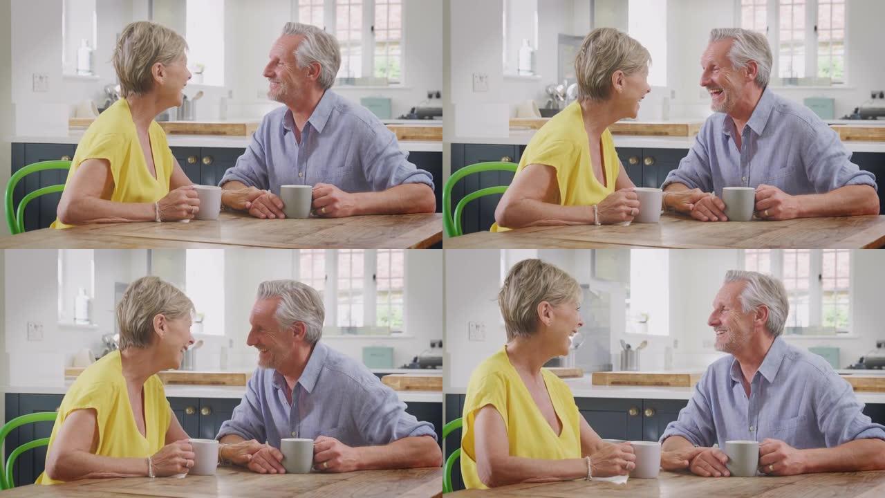 退休夫妇坐在家里的桌子旁一起喝早间咖啡