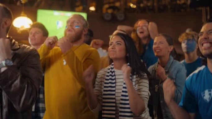 一群不同的足球迷在体育酒吧直播的足球比赛中为他们的球队欢呼。当竞争对手的球员打进决定性的进球时，焦虑
