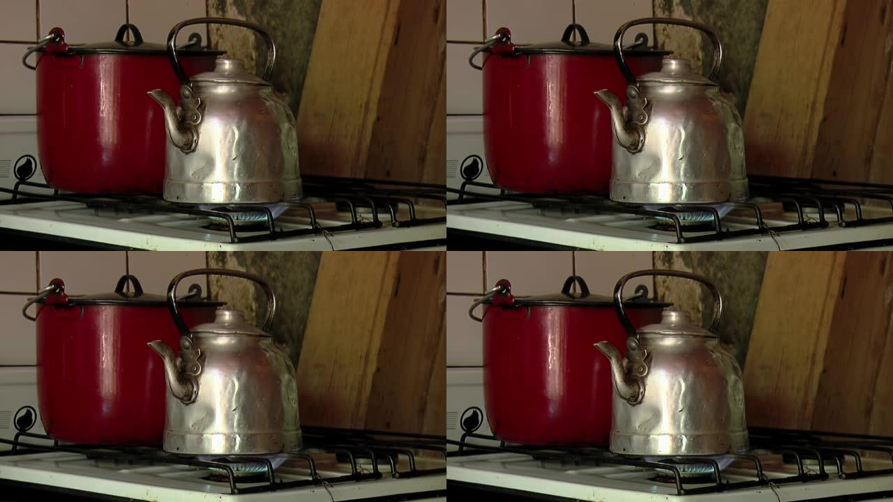 在老式厨房内的旧茶壶中加热水。特写。